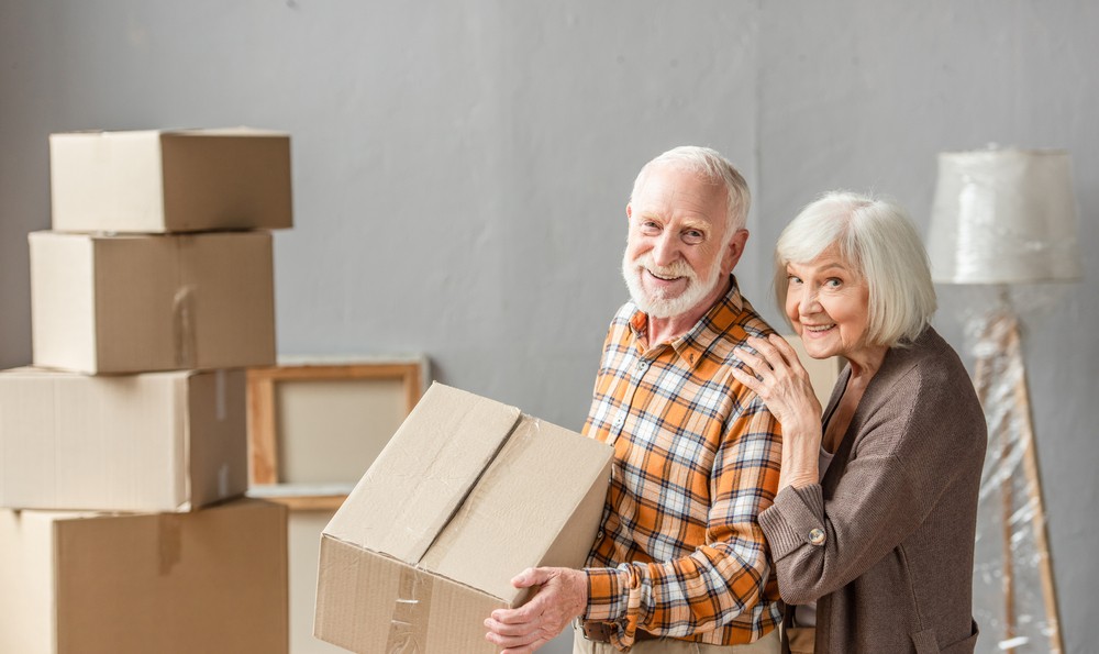 Happy senior couple moving boxes
