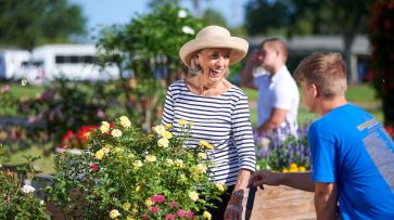 senior looking at flowers with grandson