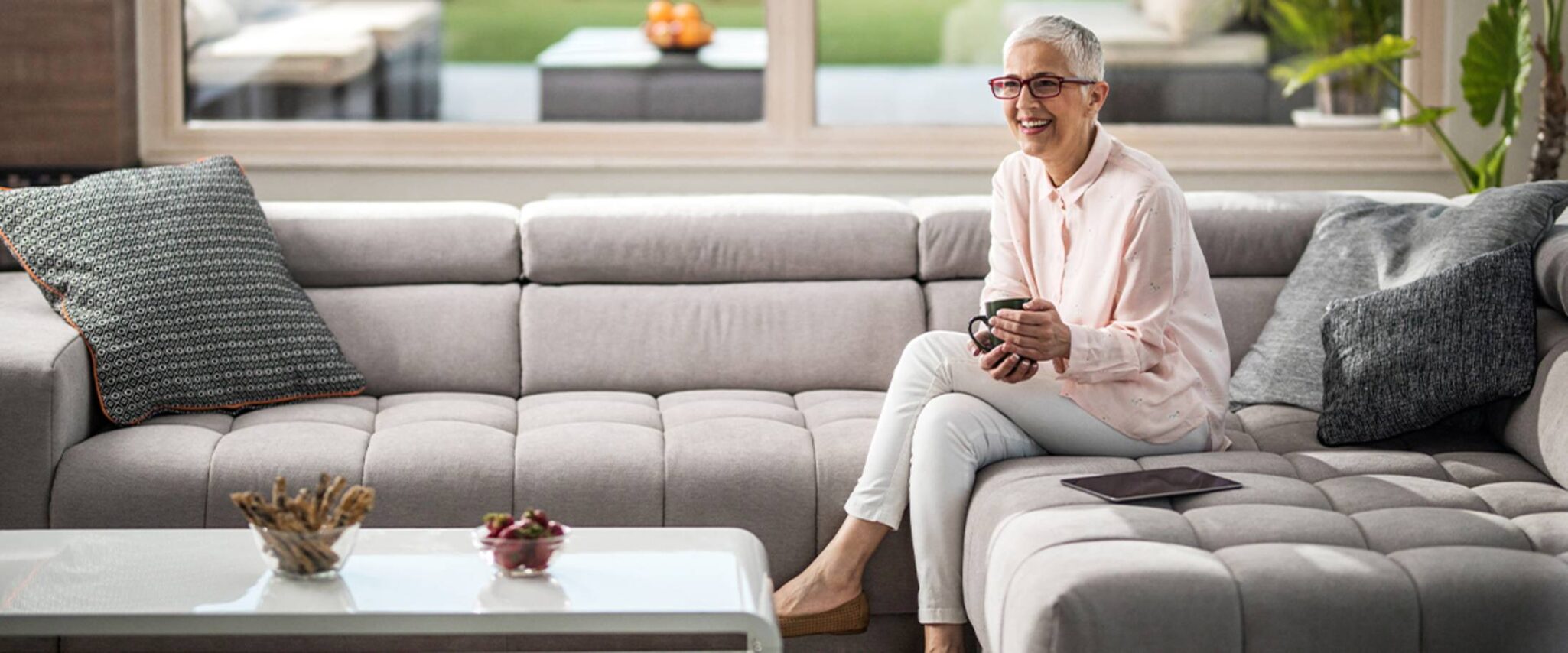 senior woman sitting on her couch in a senior living apartment