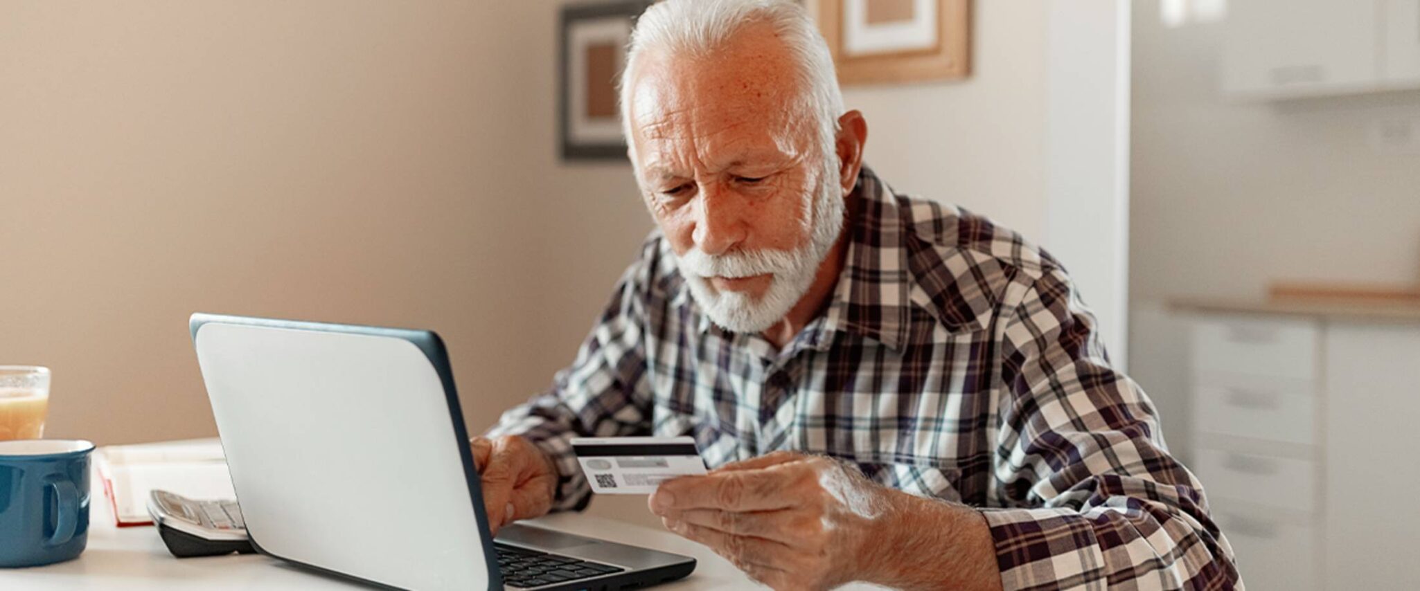 Senior man looking at his credit card