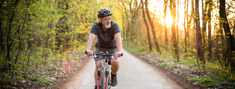 Happy senior man riding his bike