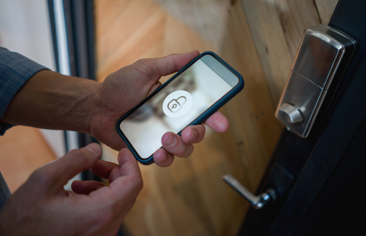 iphone being used by an elderly person to open the door to his home