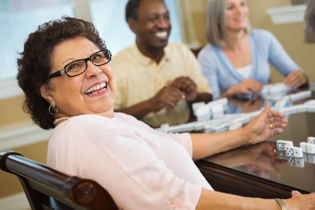 happy senior lady playing a game with dominoes