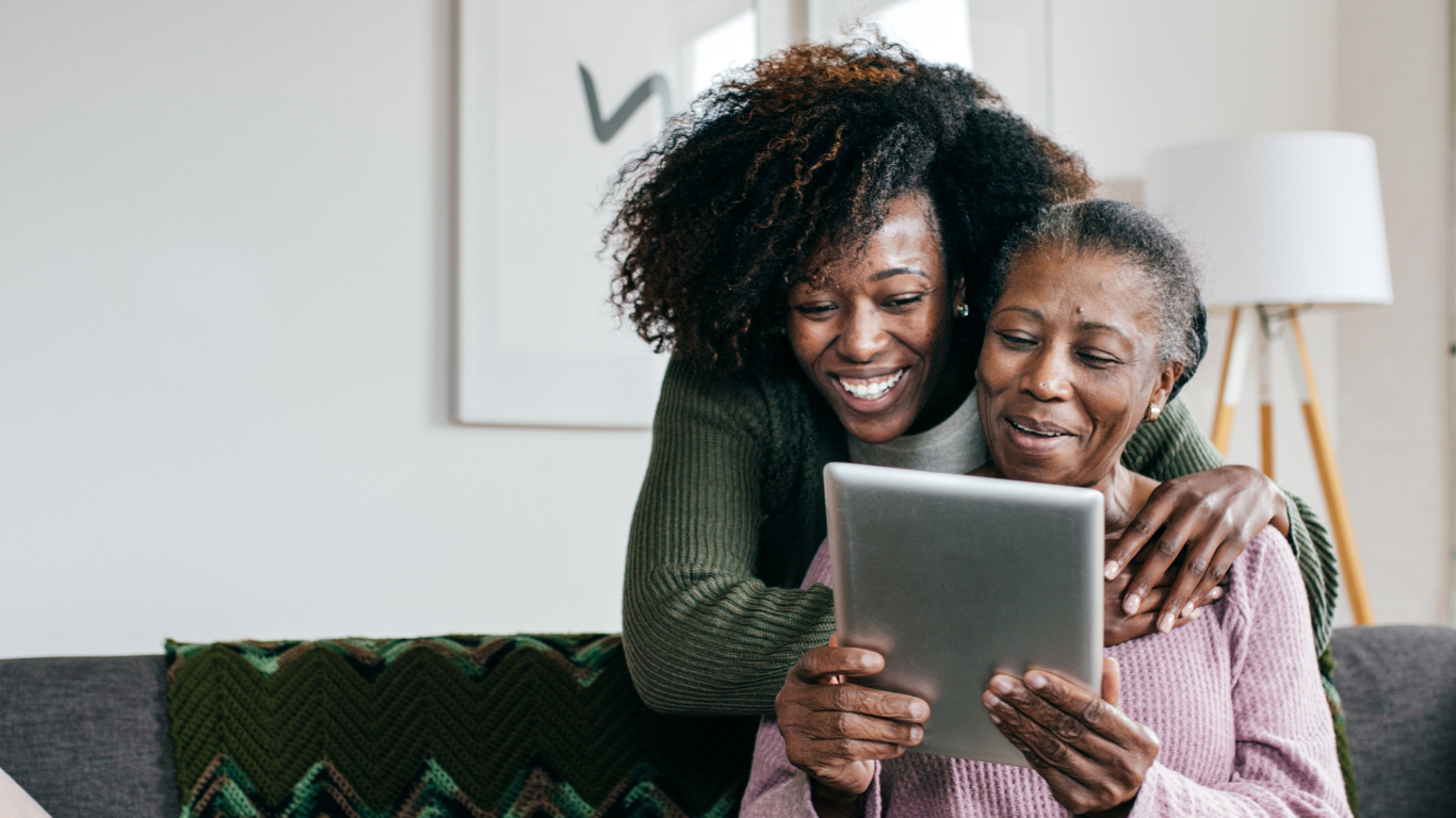 Senior woman and adult daughter looking at tablet together