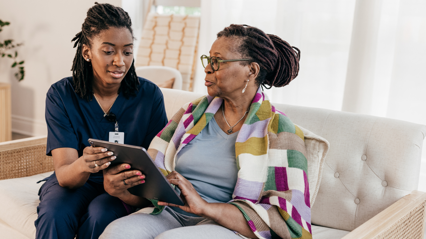 Healthcare worker and senior woman looking at tablet