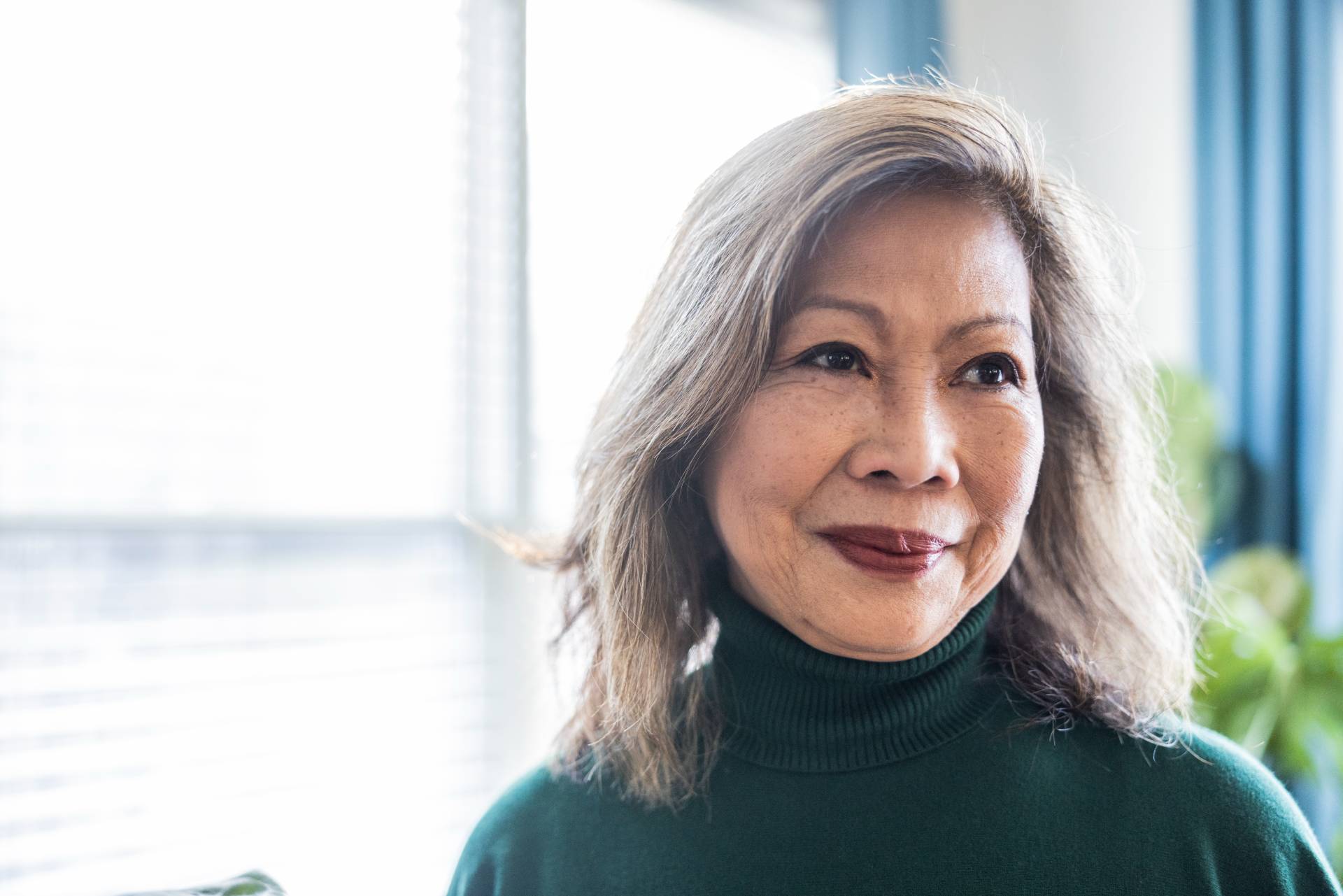 happy senior lady smiling while standing in her senior living apartment