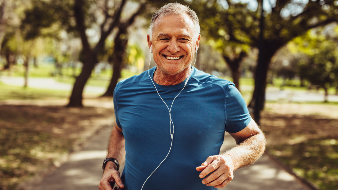 An older man on a run outside listening to wired earbuds