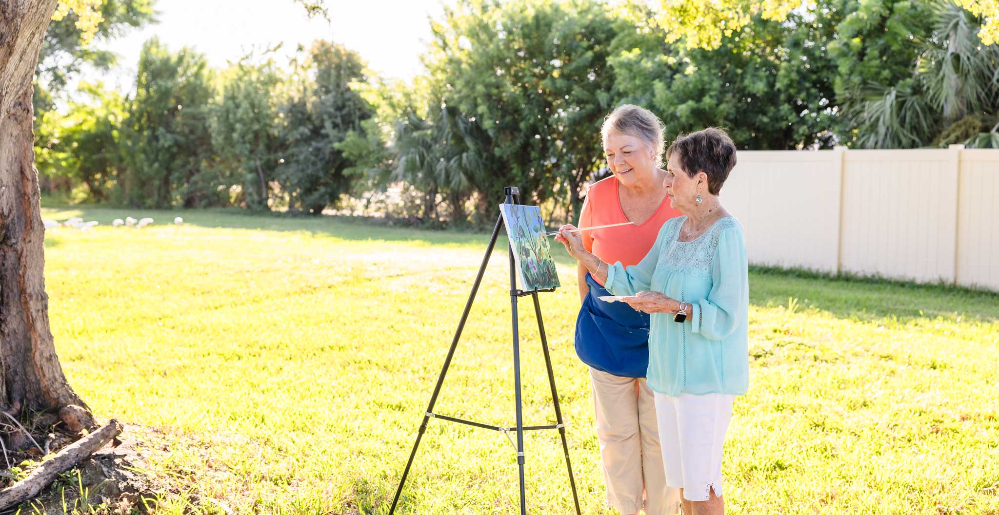 Two senior women painting outdoor