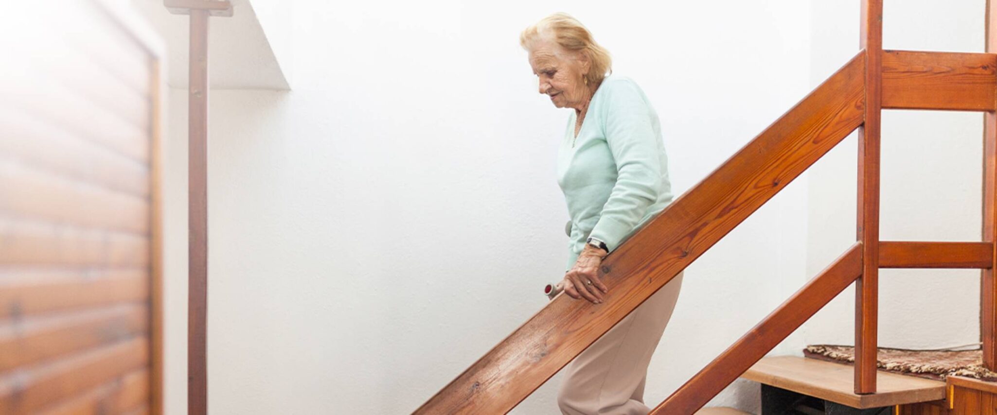 elderly woman walking down the stairs of a senior apartment