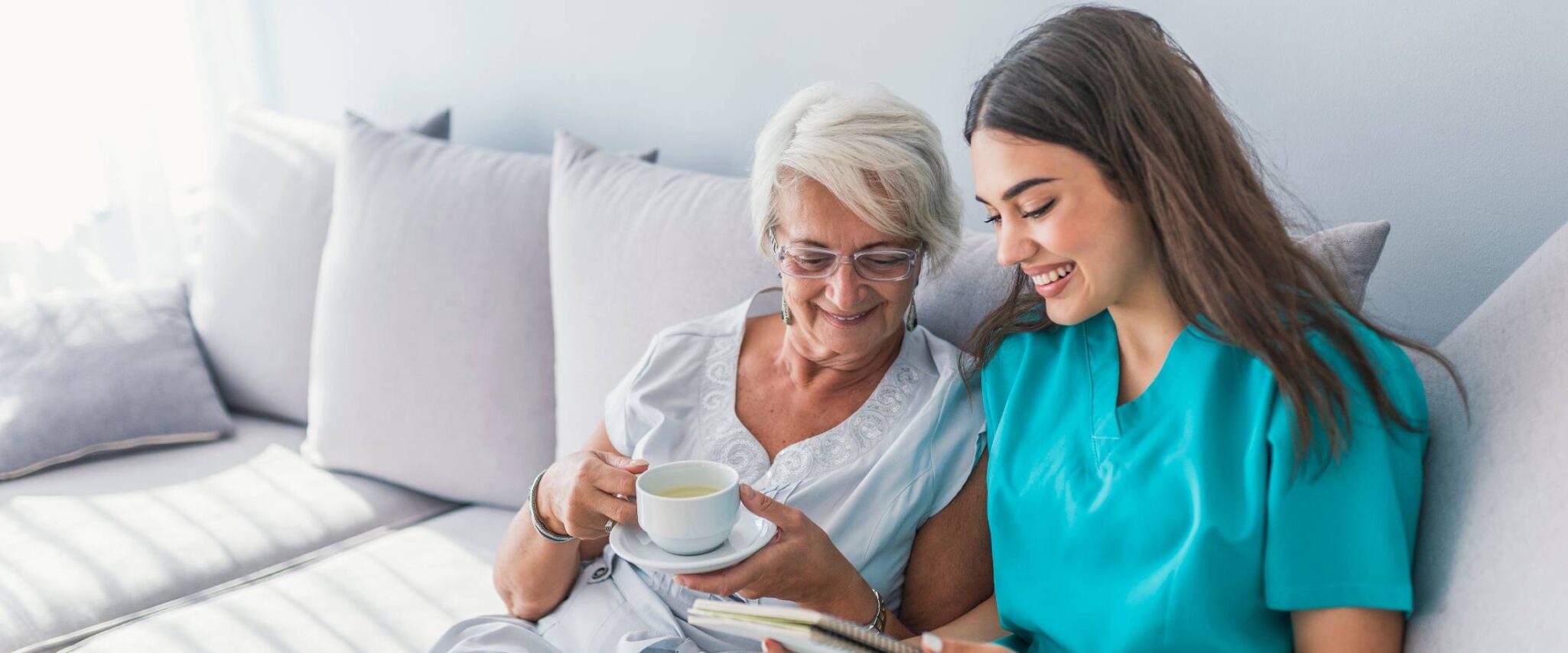 senior with nurse sitting on a couch