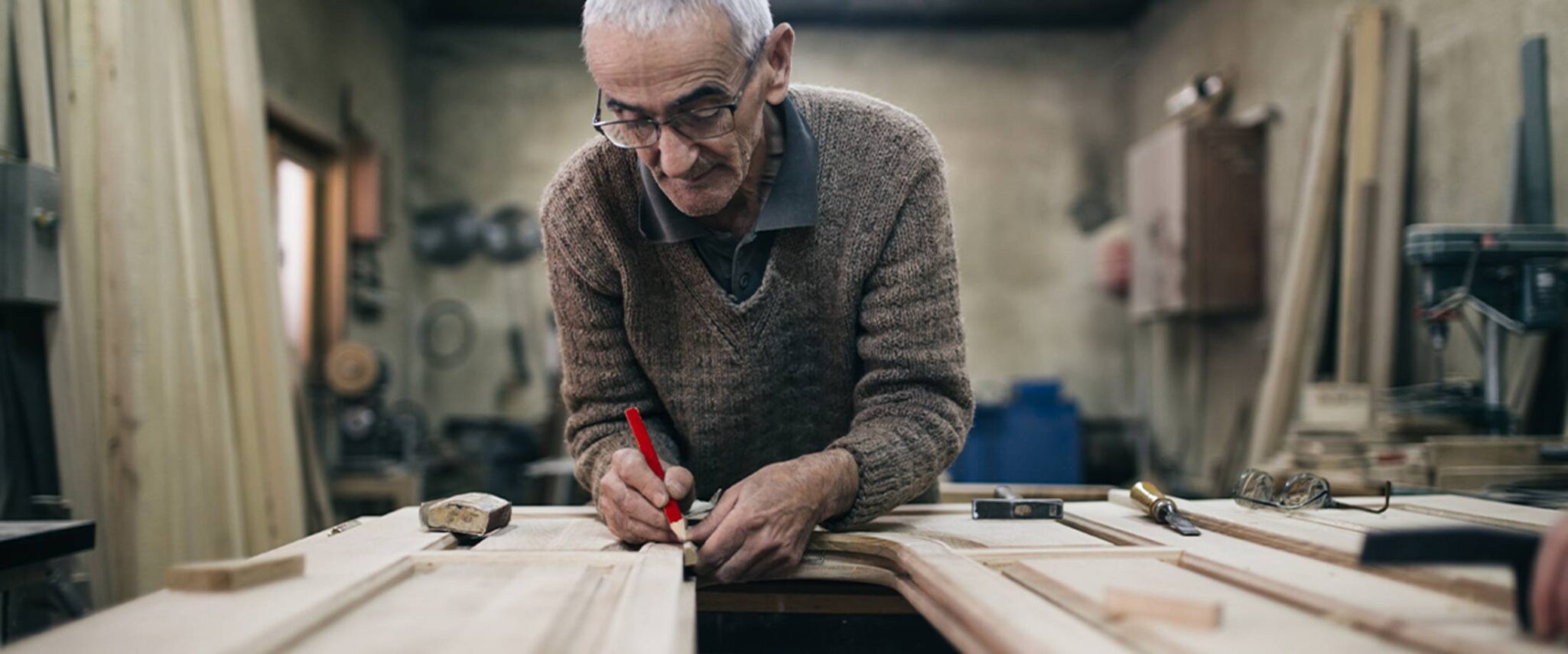 Elderly man woodworking in a senior living community