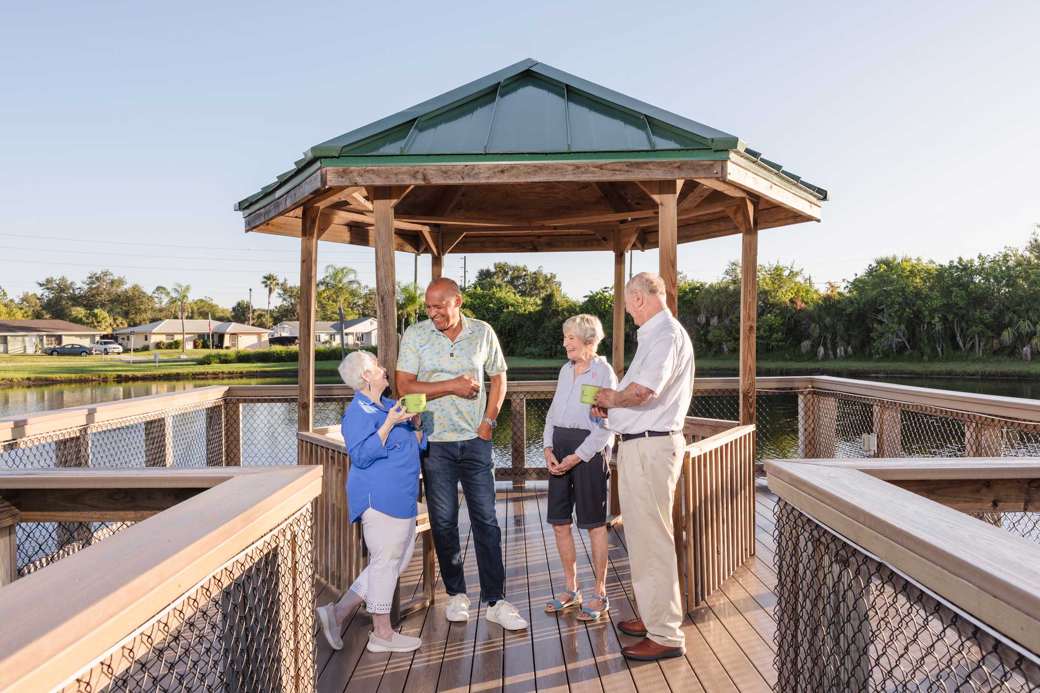 Two senior couples enjoying drinks on dock